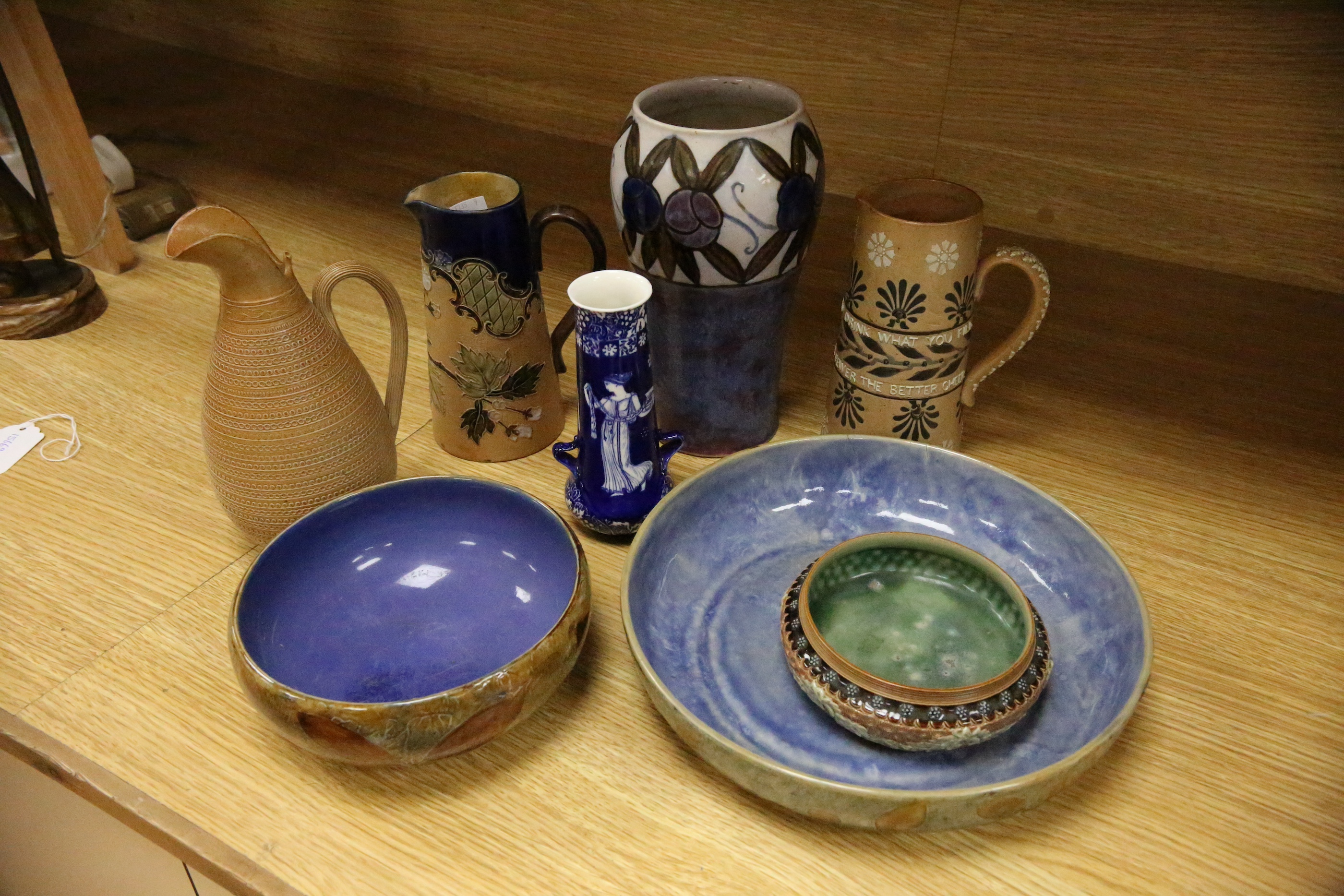 Three Royal Doulton jugs, two vases and two natural foliage ware dishes, tallest vase 23cm high. Condition - smallest jug cracked near rim, two handled vase glazing blemish near base